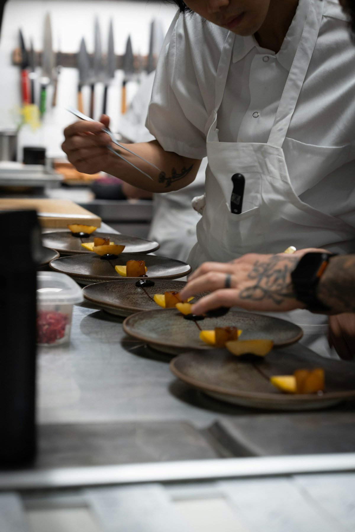 Chef plating a dish under the pass